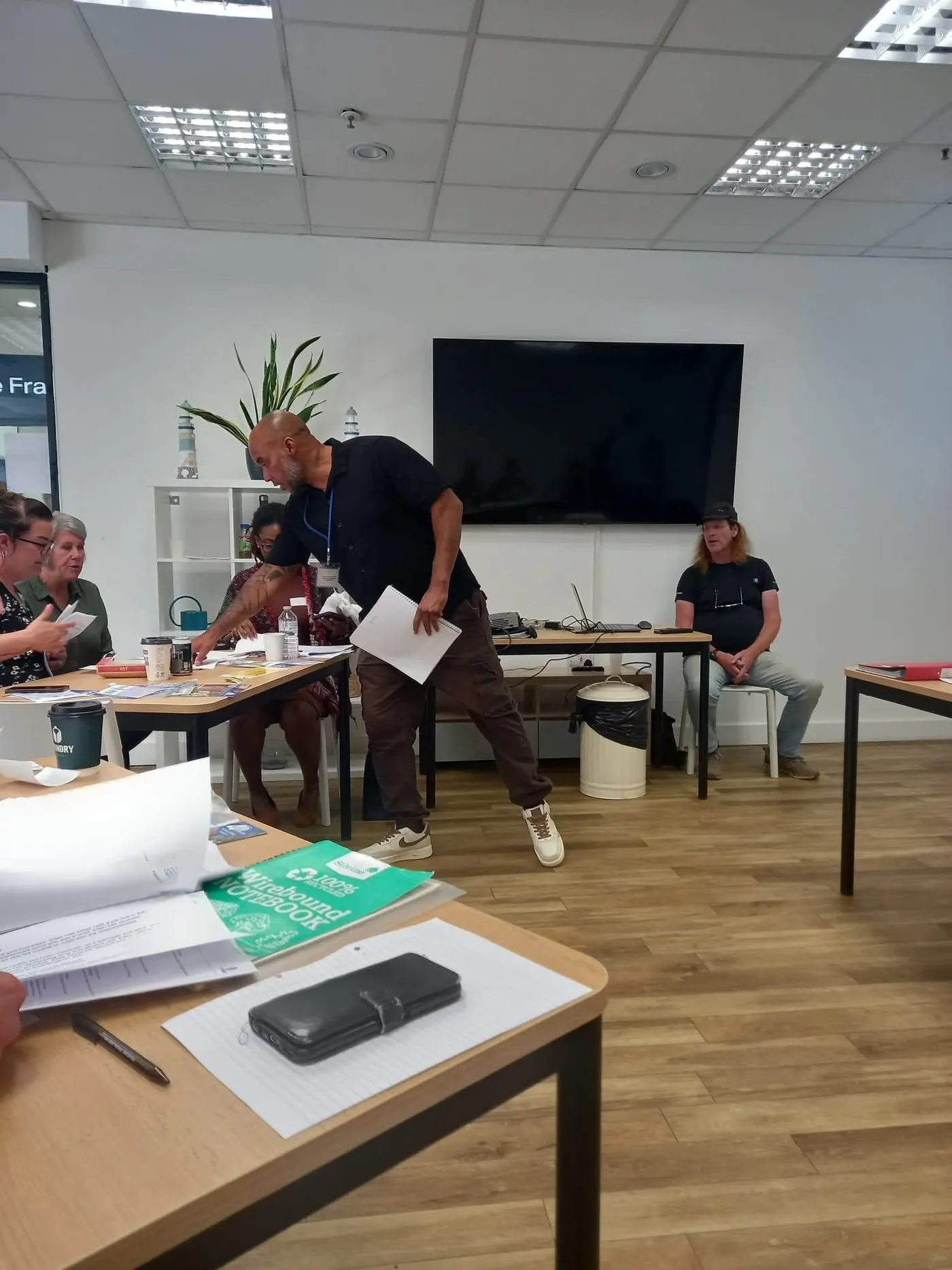 Taff Jones facilitating a workshop as staff work around tables